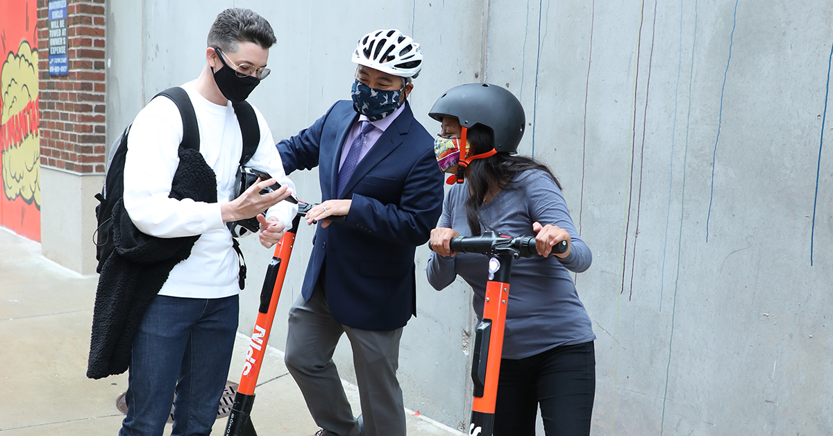 3%20people-looking%20at%20app-2%20on%20scooters.jpg