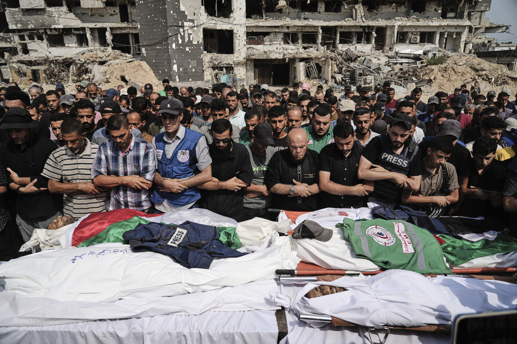 Palestinians pray over the bodies of journalists, including Al Jazeera correspondents Anas al-Sharif and Mohamed Qreiqeh, who were killed in an Israeli airstrike, during their funeral outside Gaza City's Shifa hospital complex.