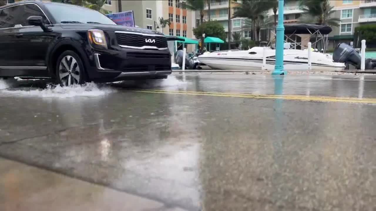 Vehicle travels through sitting rainwater at entrance to Boynton Harbor Marina, Nov. 15, 2023