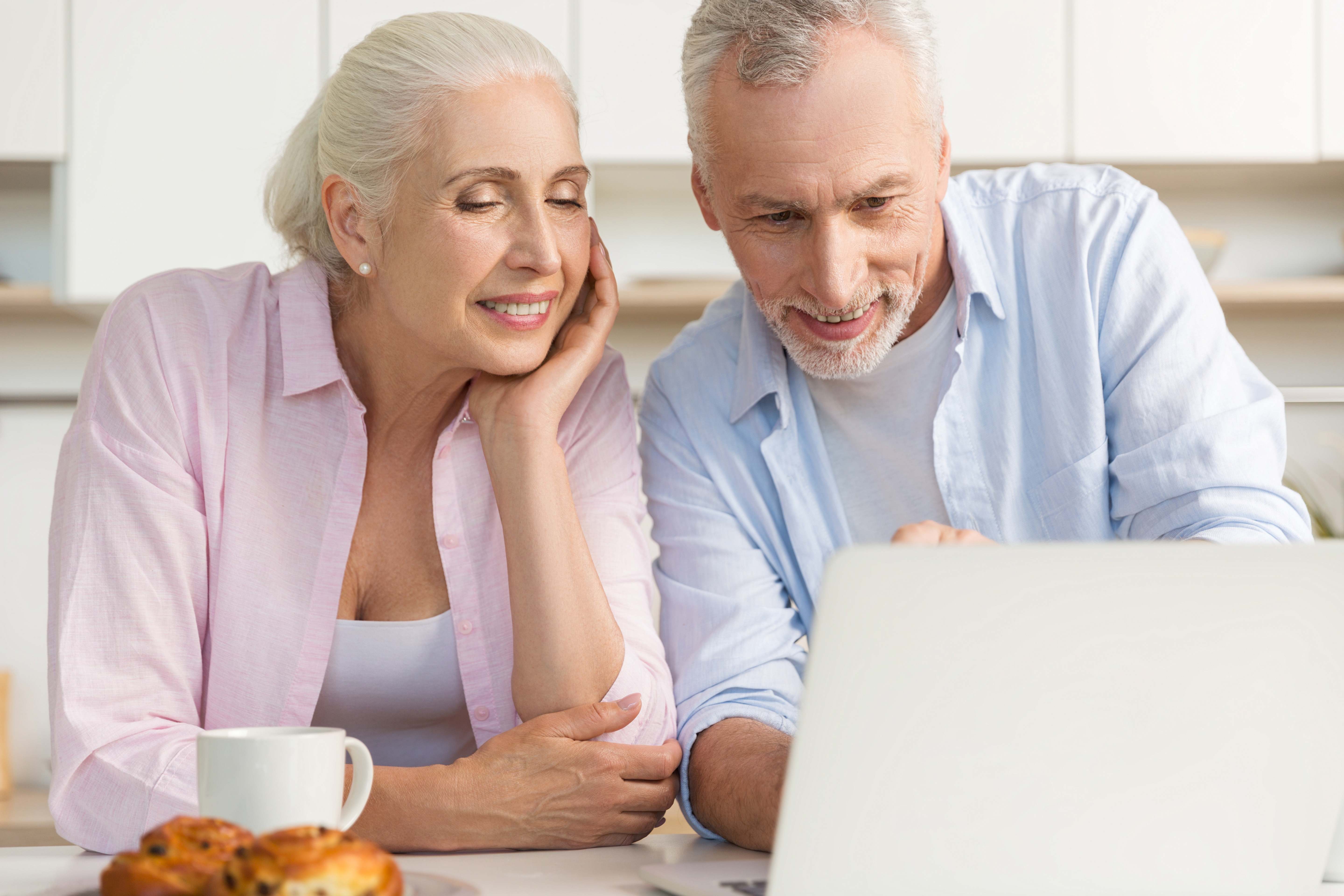 Happy mature loving couple family using laptop computer