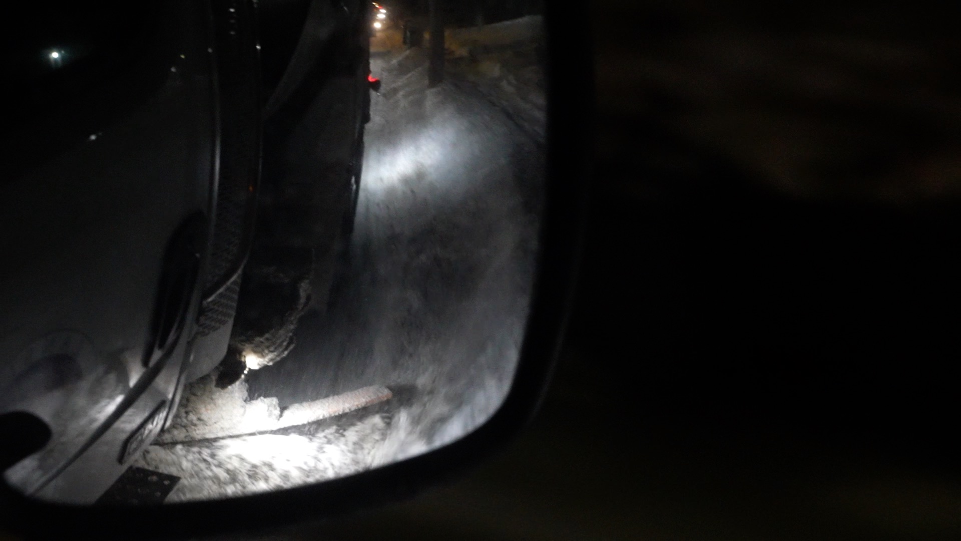 Snow plow side mirror looking at snow being cleaned in Lansing
