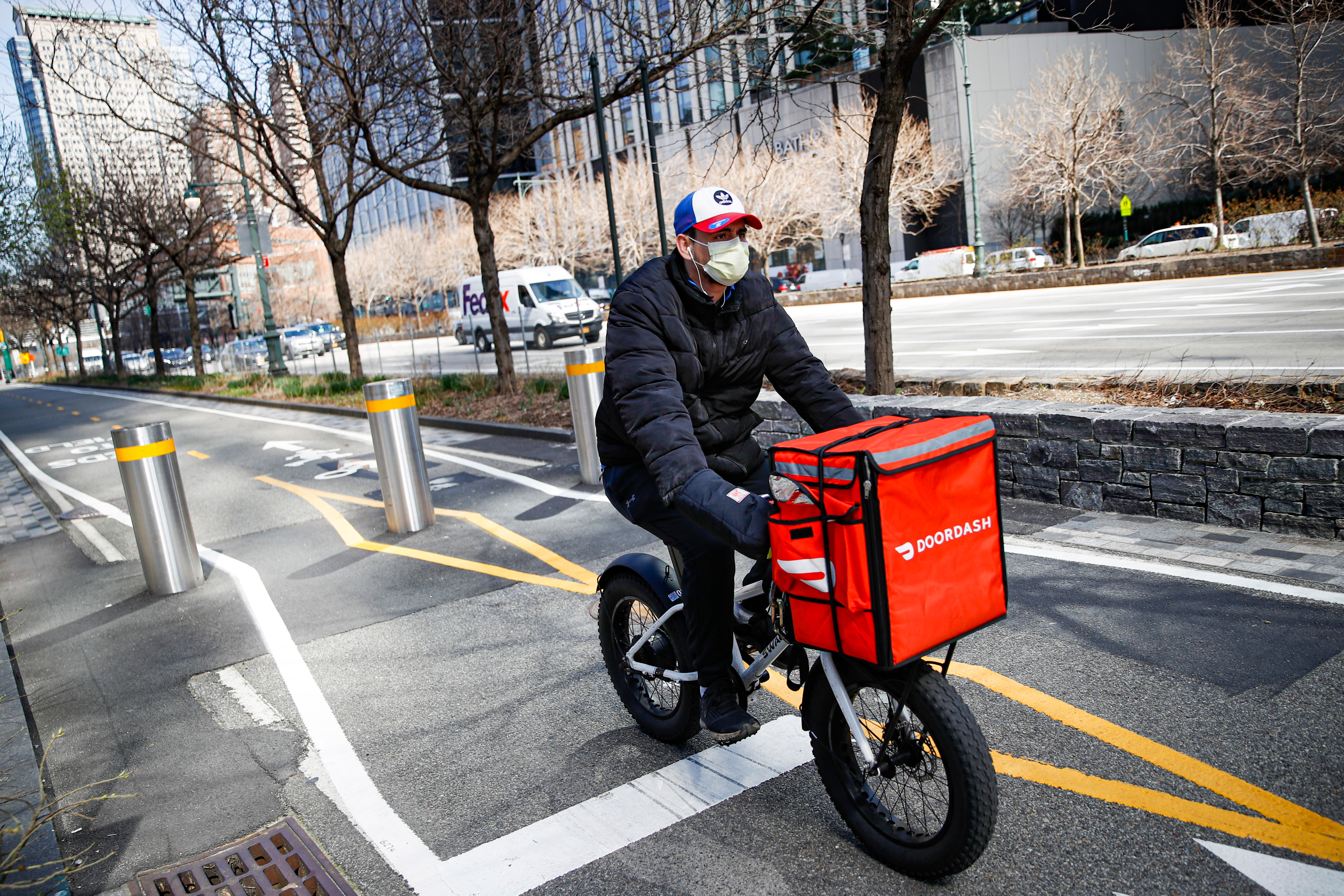 FILE - A delivery worker rides his bicycle along a path on the West Side Highway in New York on March 16, 2020.