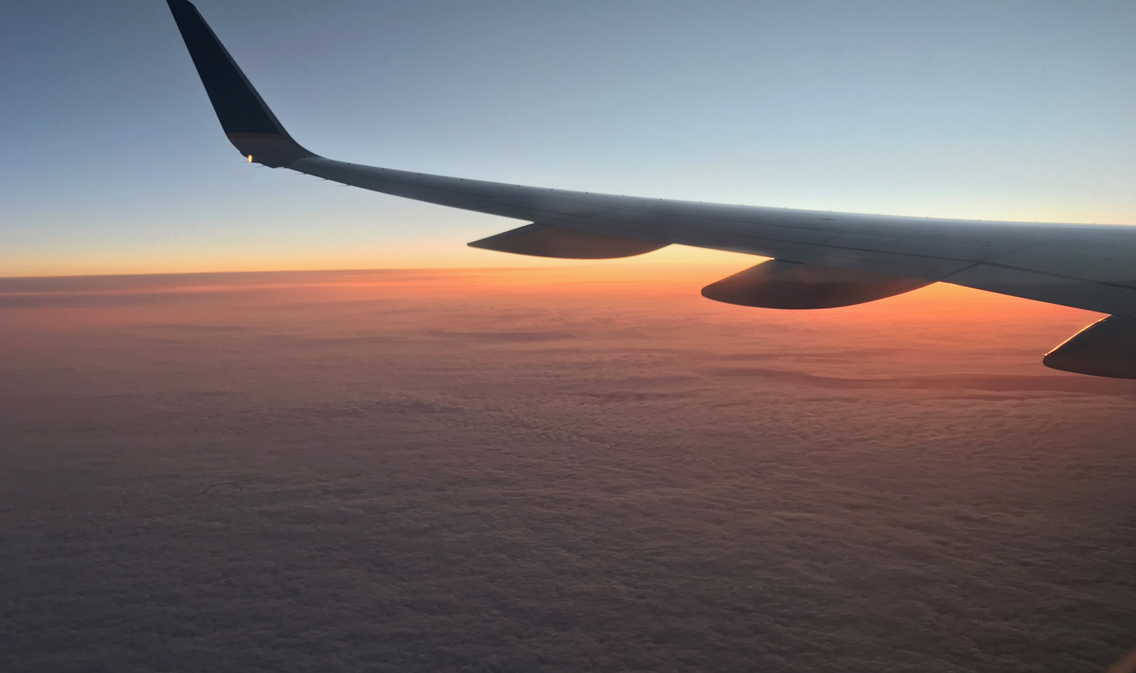 Airplane flying at sunrise.