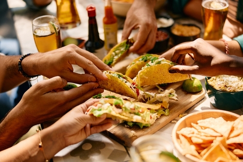 Stock image of people eating tacos.