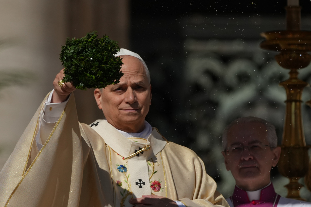 Pope Leo XIV sprinkles holy water with a bunch of hyssop sprigs as he presides over Easter Mass in St. Peter's Square at the Vatican, Sunday, April 5, 2026.
