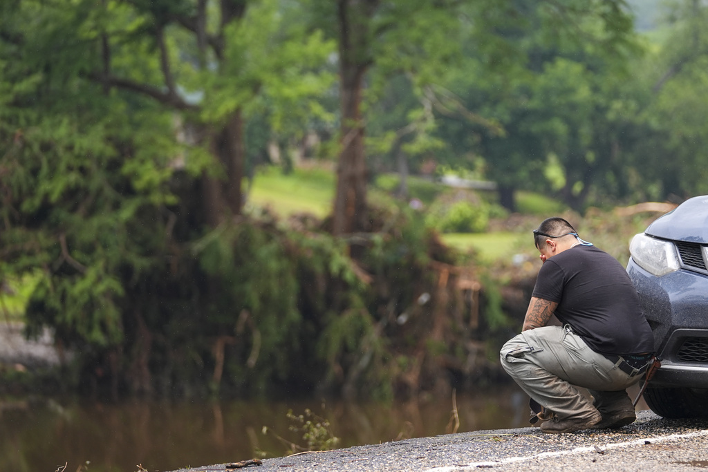 Avi Santos, 23, of San Antonio, Texas, reacts while stopping on the road alongside at Camp Mystic along the banks of the Guadalupe River after a flash flood swept through the area.