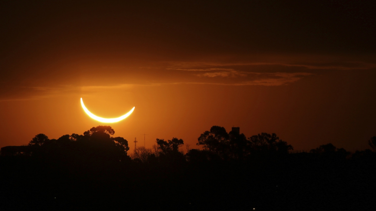 The moon passes in front of the setting sun during a total solar eclipse in Buenos Aires, Argentina.