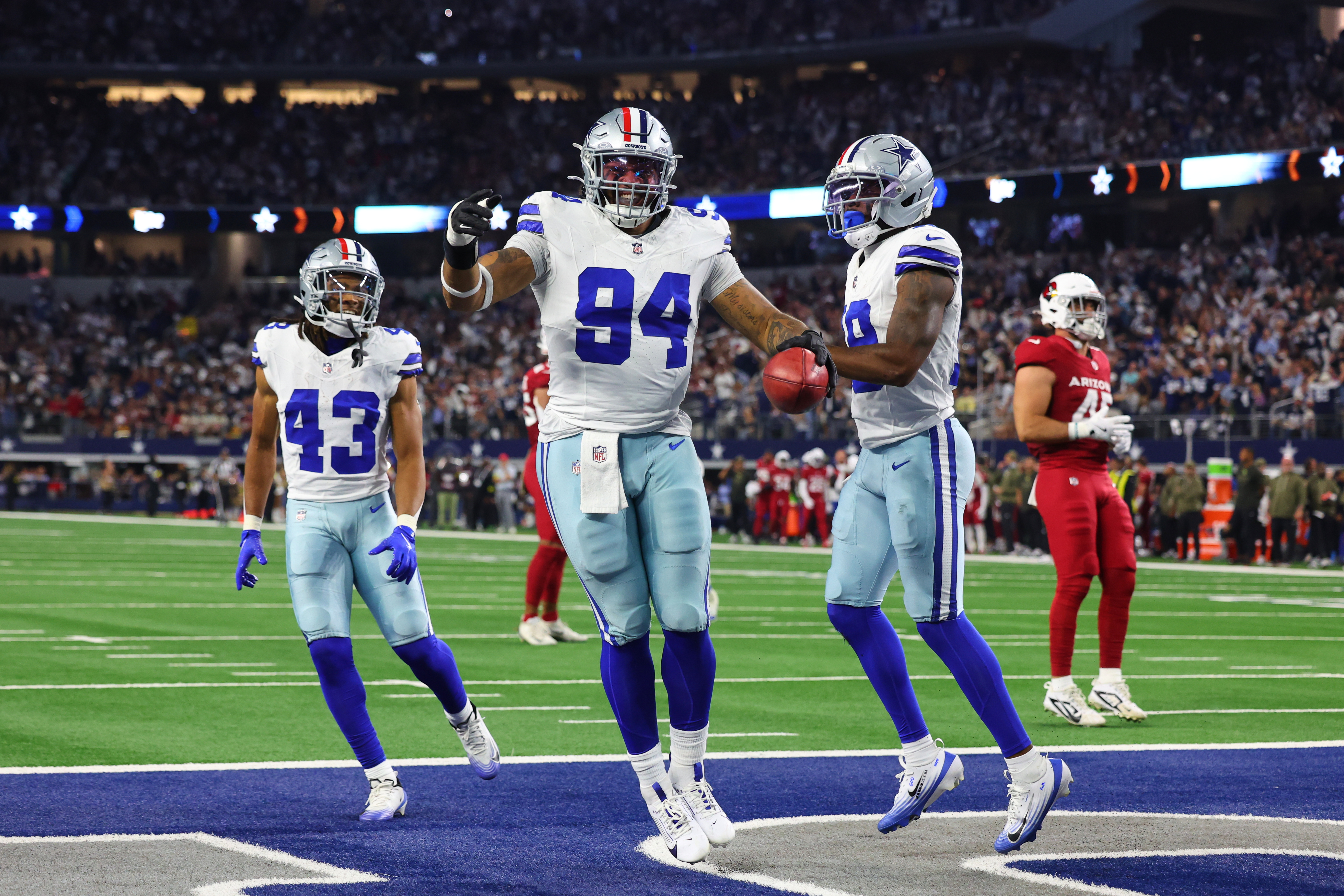 Dallas Cowboys defensive end Marshawn Kneeland (94), Malik Davis (43) and Damone Clark, right, celebrate after Kneeland recovered a blocked punt for a touchdown in the first half of an NFL football game against the Arizona Cardinals Monday, Nov. 3, 2025, in Arlington, Texas. 