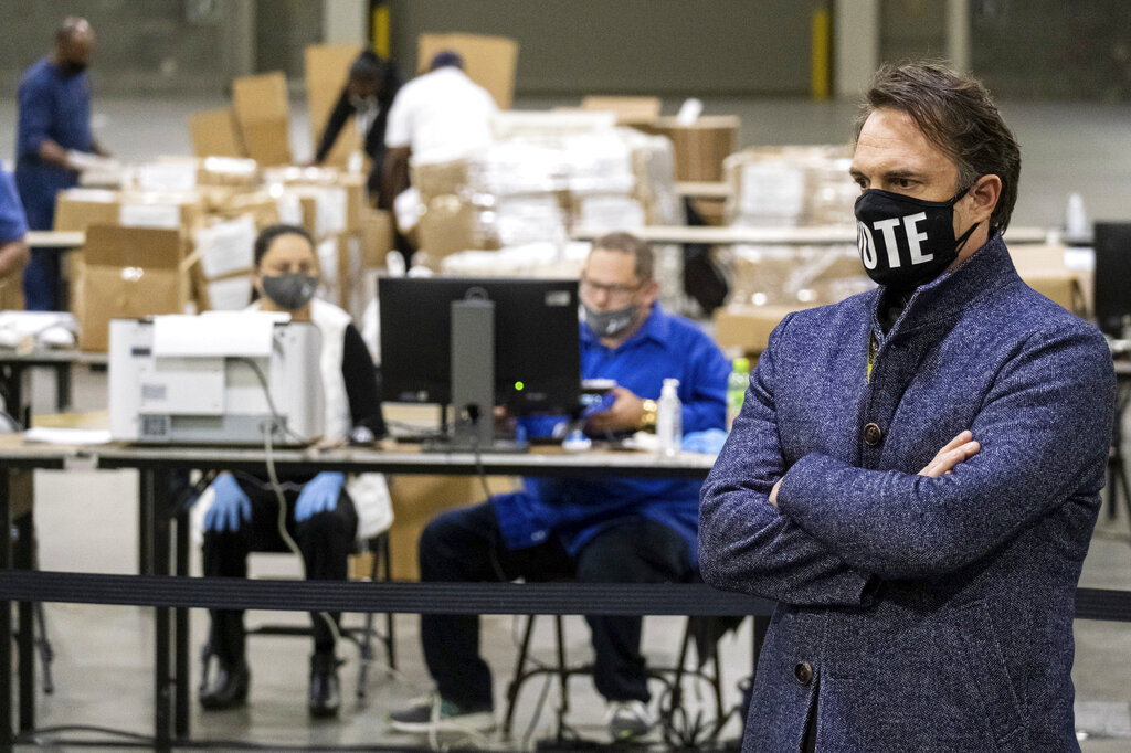 In this Nov. 25, 2020 file photo, Fulton County Georgia election chief Rick Barron talks to reporters as workers scan ballots during a presidential recount in Atlanta. 