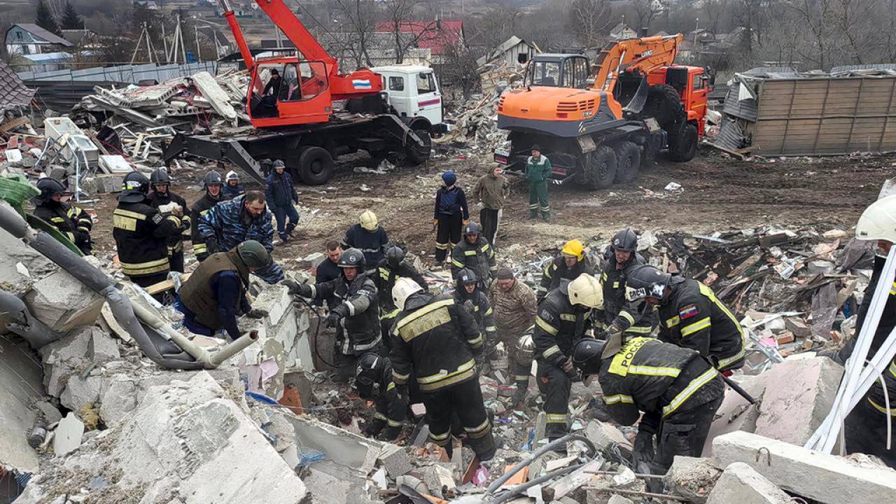 Emergency ministry employees working at a destroyed building after shelling from the Ukrainian side.