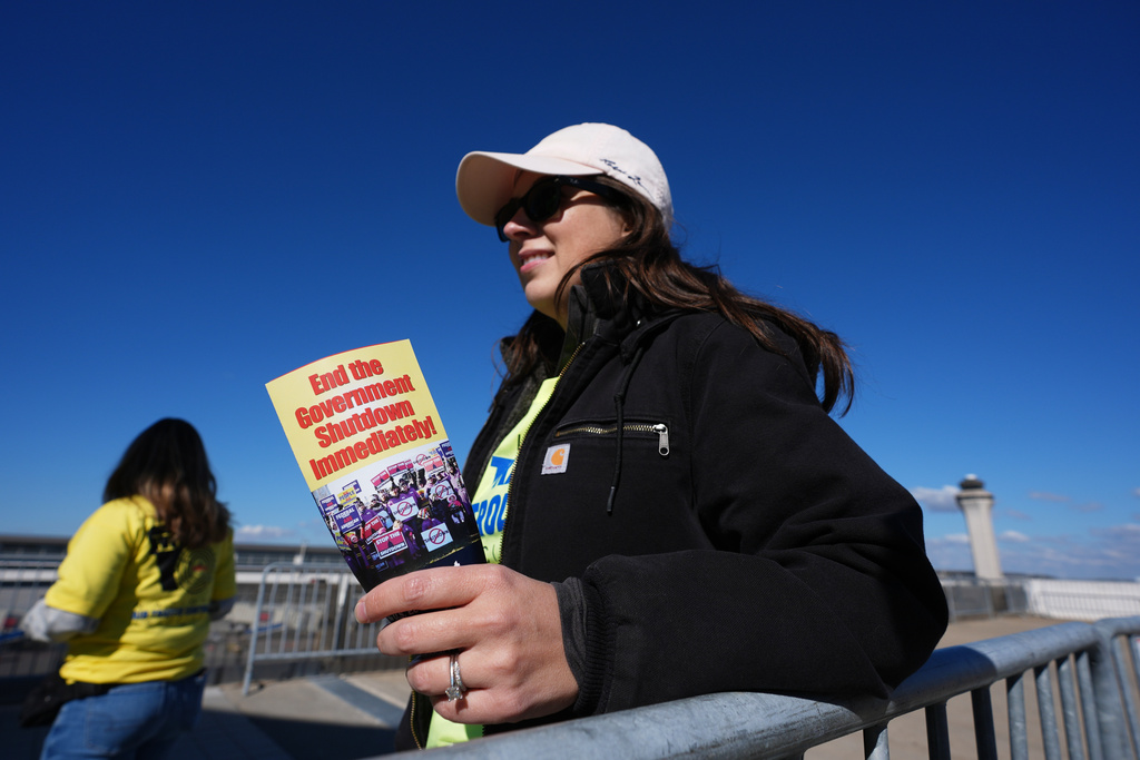 Air Traffic Controller Claudia Peterfeso distributes leaflets explaining how the federal government shutdown is impacting air travel at Detroit Metropolitan Wayne County Airport.