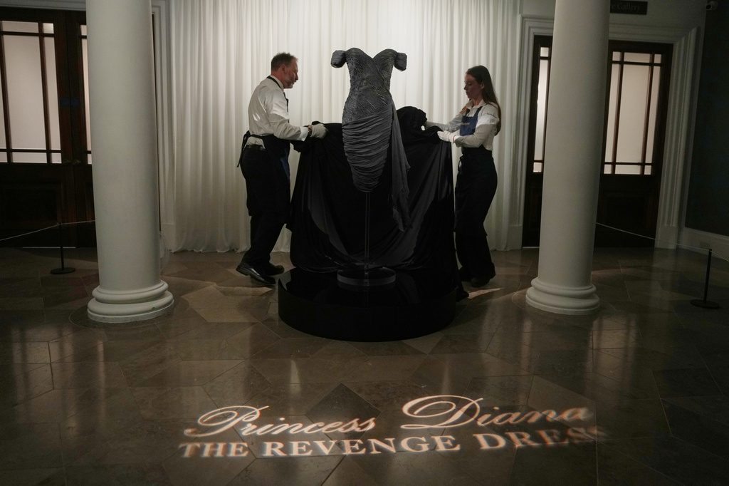 A dress worn by the late Princess Diana and known as the ''Revenge Dress'', designed by Christina Stambolian, is unveiled by staff at Sothebys auction house in London, Friday, Sept. 18, 2026, ahead of its Dec. 9 auction in New York, where it is estimated to sell for US$150,000-300,000.