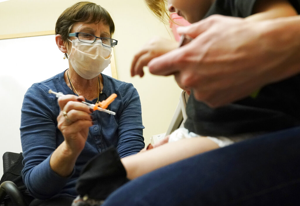 A nurse gives a vaccine shot to a 20-month-old child in Seattle. 