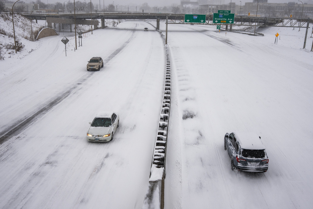 People drive on a snow-covered freeway during a snow storm Sunday, March 15, 2026, in Minneapolis.