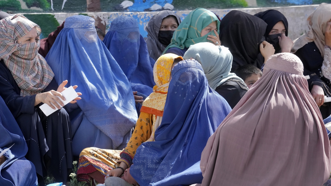 Afghan women wait to receive food rations distributed by a Saudi humanitarian aid group
