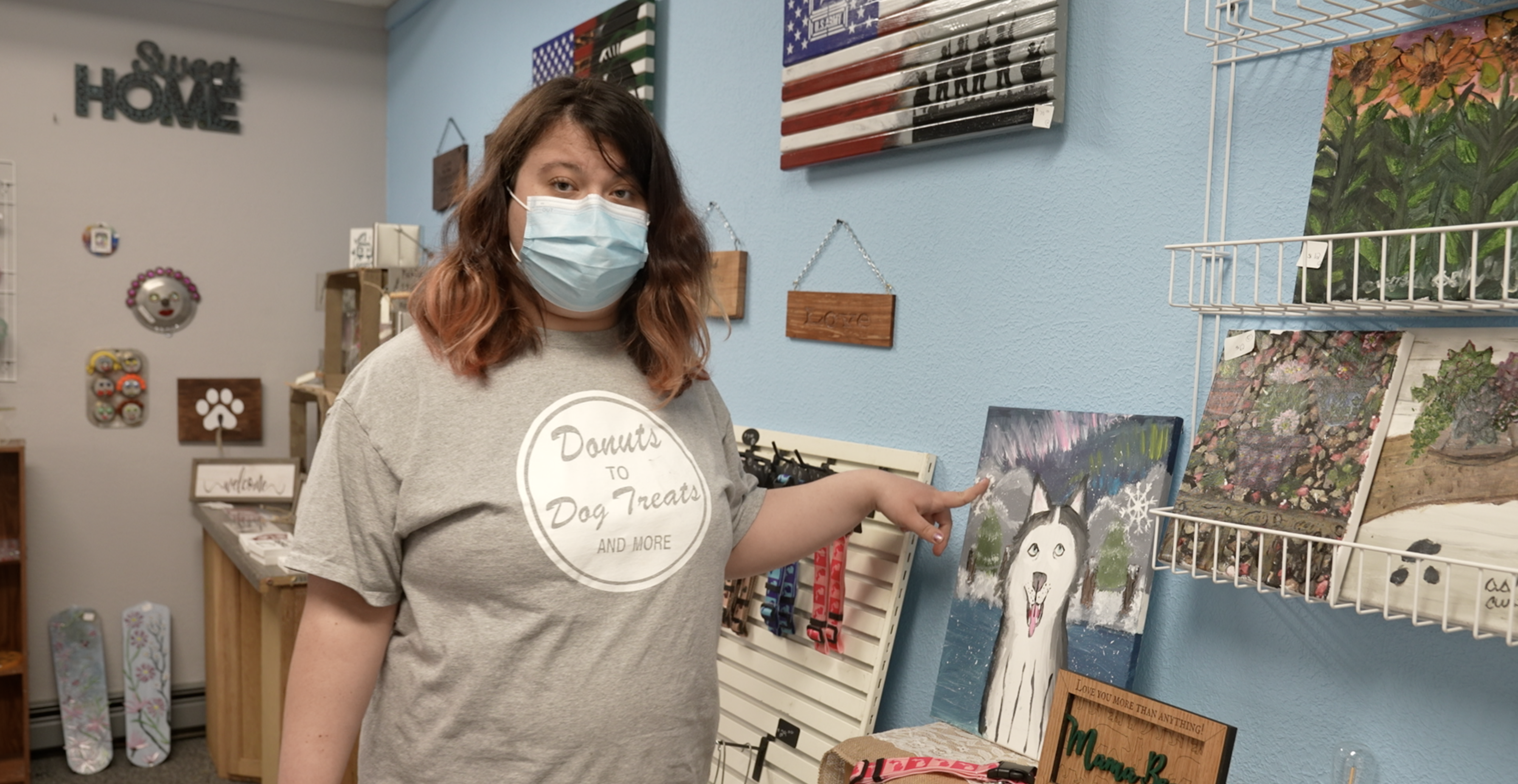 Ashley Curtis is pointing at her painting 