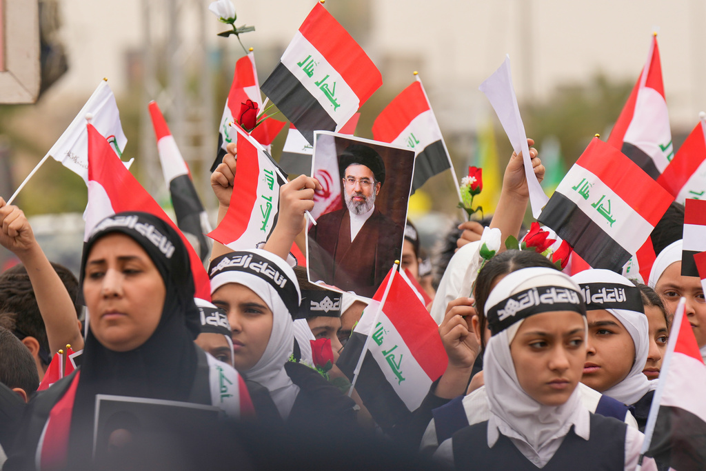 Iraqis hold a portrait of the new successor to Supreme Leader Ayatollah Mojtaba Khamenei during a protest against U.S. and Israeli attacks on multiple cities across Iran, in Baghdad, Iraq, Thursday, March 12, 2026. 
