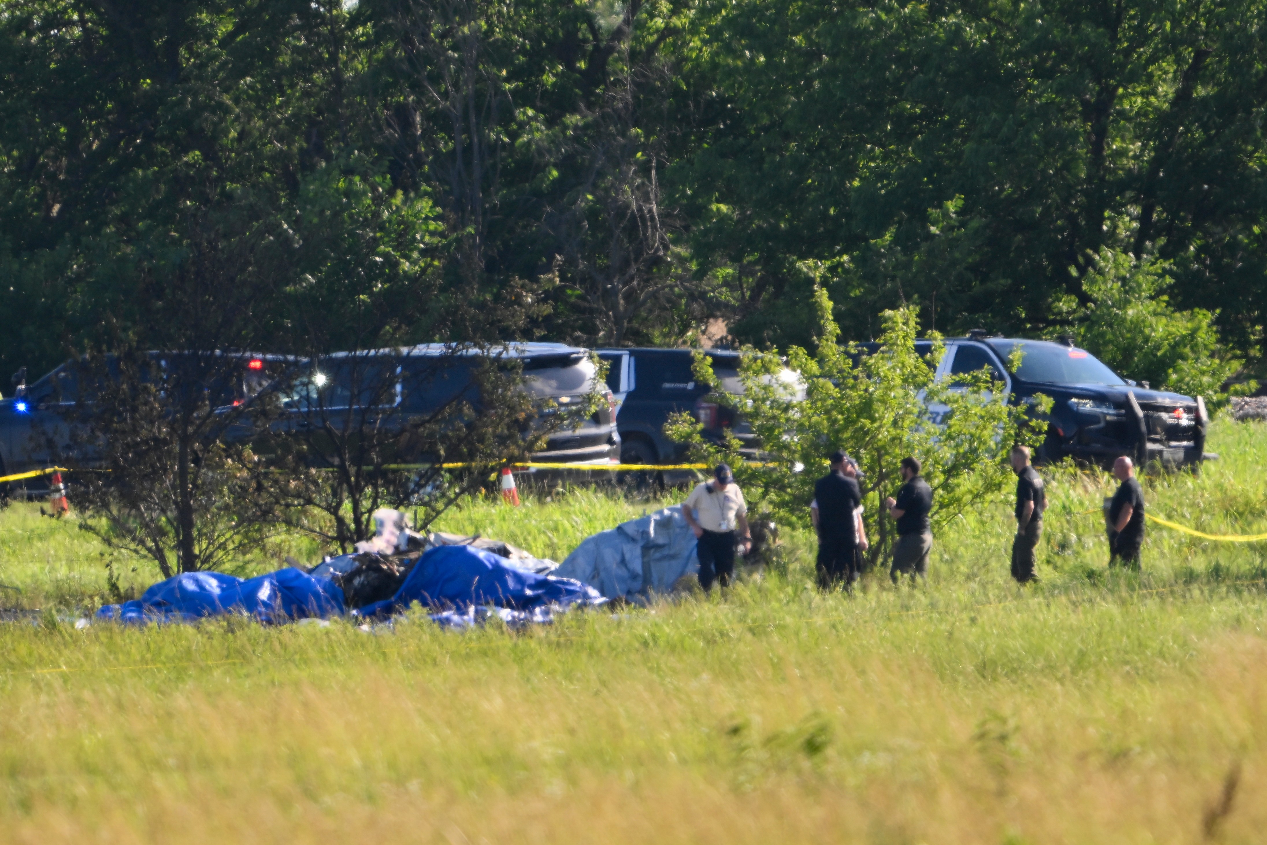 Emergency personnel investigate the site of a plane crash at the Butler Memorial Airport in Butler, Mo., Sunday, June 14, 2026.