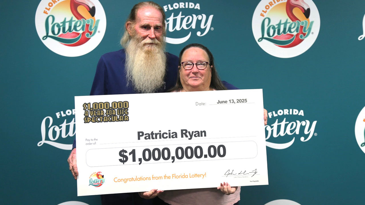 Patricia Ryan and her husband pose with an oversized check after claiming a $1 million prize from the $1,000,000 A YEAR FOR LIFE SPECTACULAR Scratch-Off game at Florida Lottery Headquarters in Tallahassee.