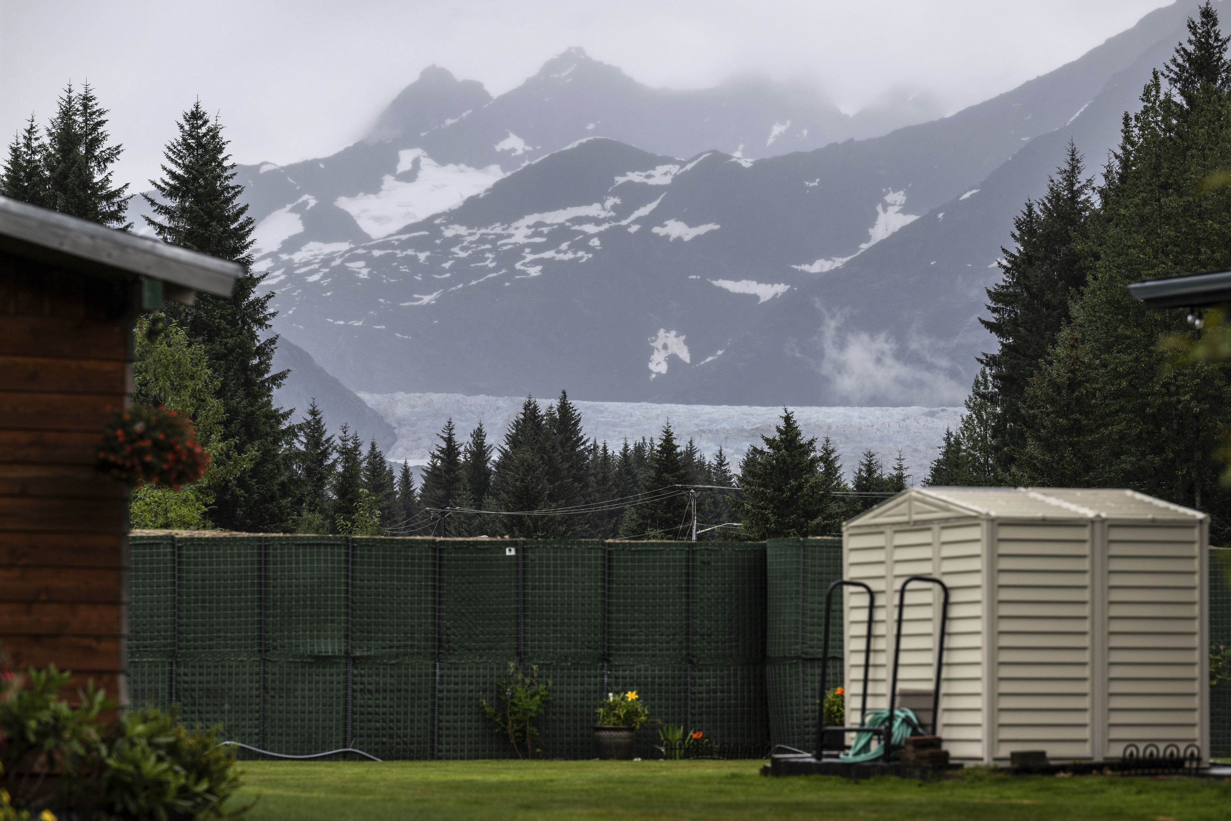 The Mendenhall Glacier is visible in the distance from a residential area, Sunday, Aug. 3, 2025, in Juneau, Alaska.  