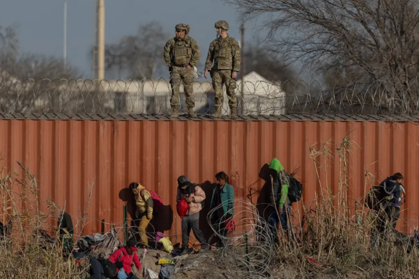 Migrants traverse the bank of the Rio Grande at Shelby Park in Eagle Pass, on Jan. 19, 2024. A federal judge on Thursday blocked. 
