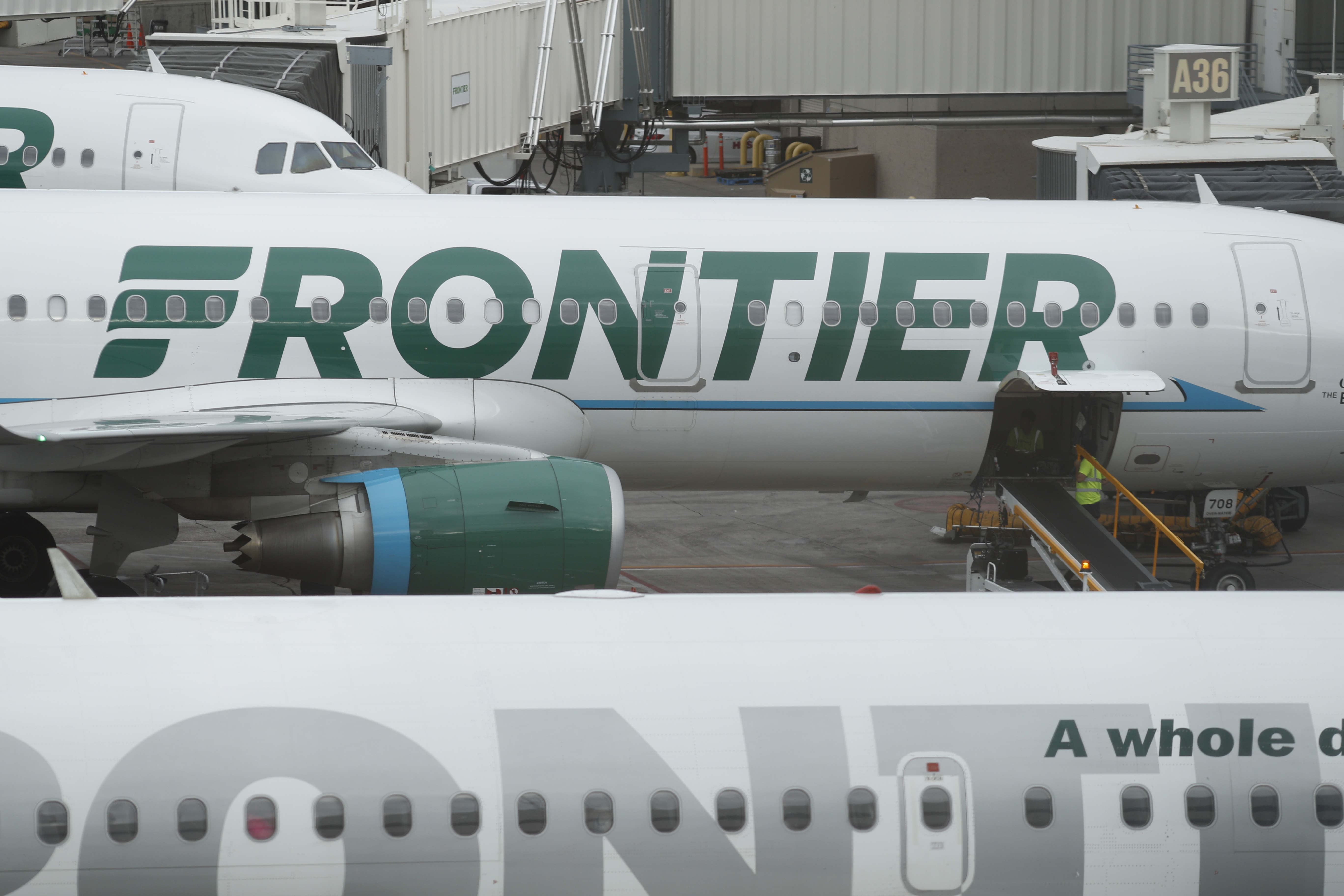 In this Monday, May 15, 2017, photograph, the company logo is showcased on the side of a Frontier Airlines airplane waiting at a gate on Concourse A in Denver International Airport in Denver.