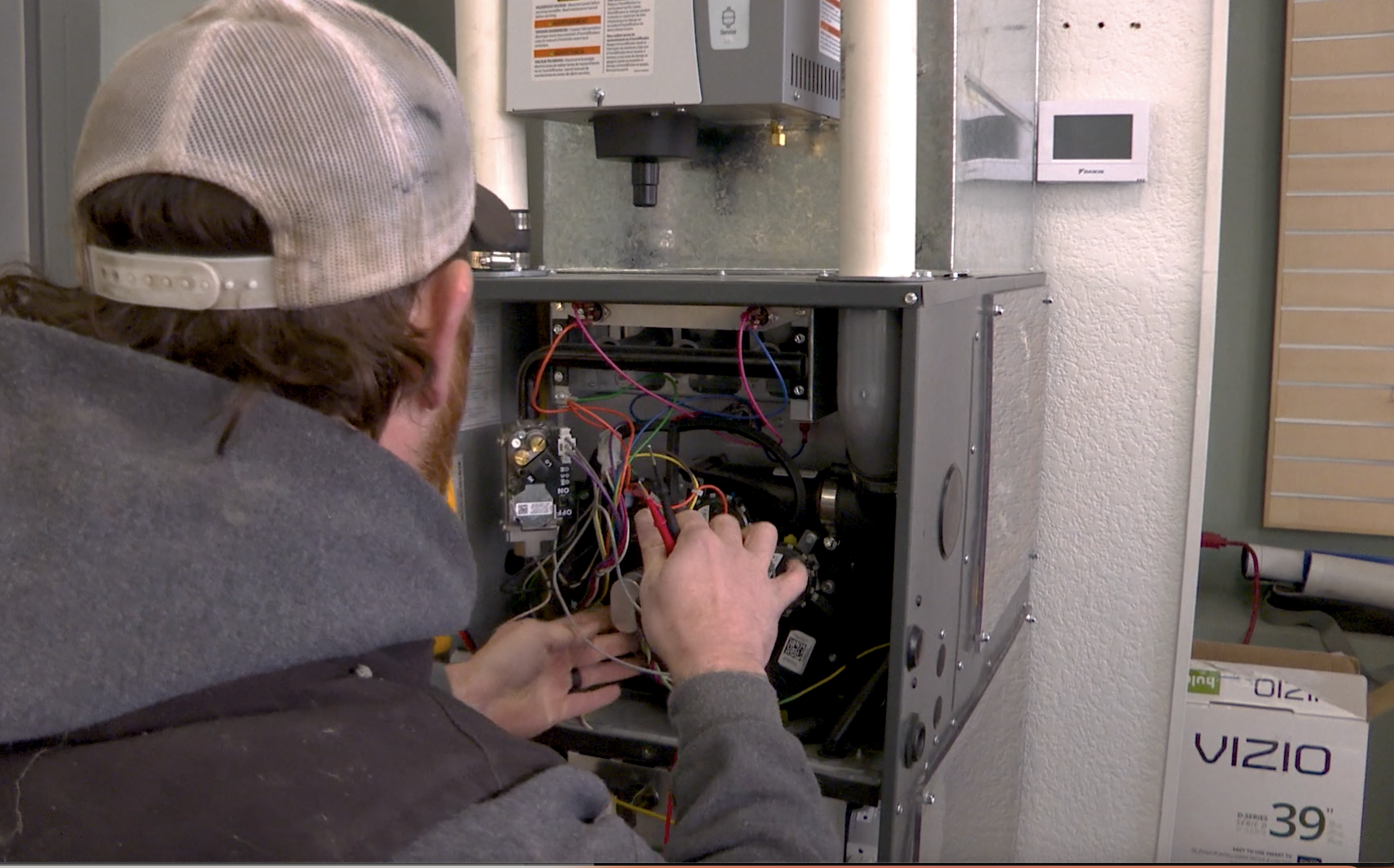 An HVAC technician fixes a heater