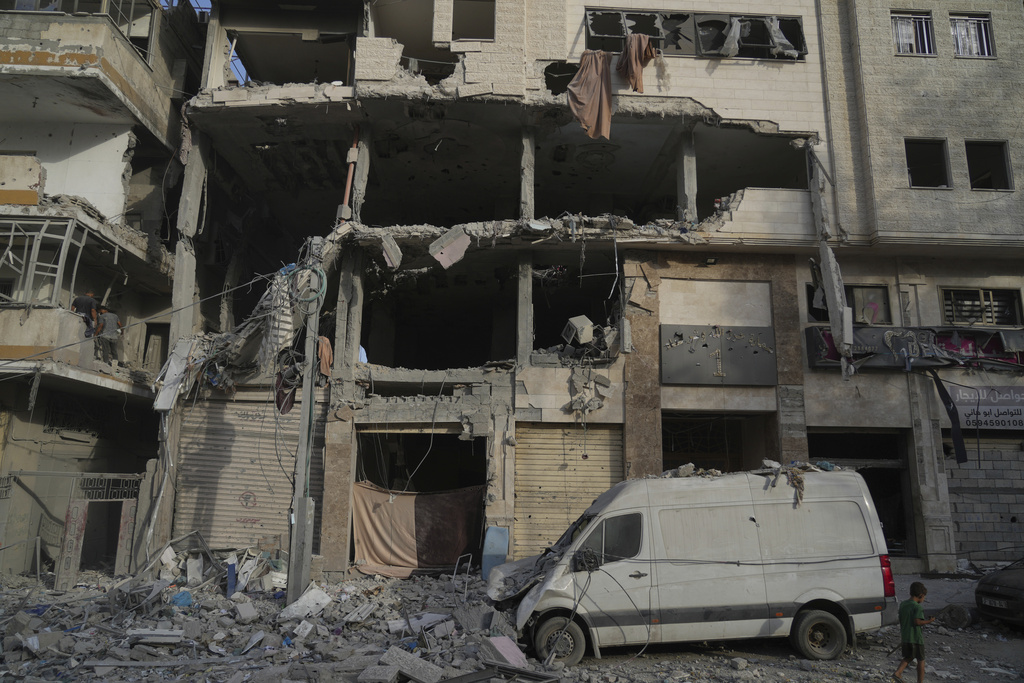 A Palestinian boy walks past a heavily damaged building in the Rimal neighborhood, in Gaza City.