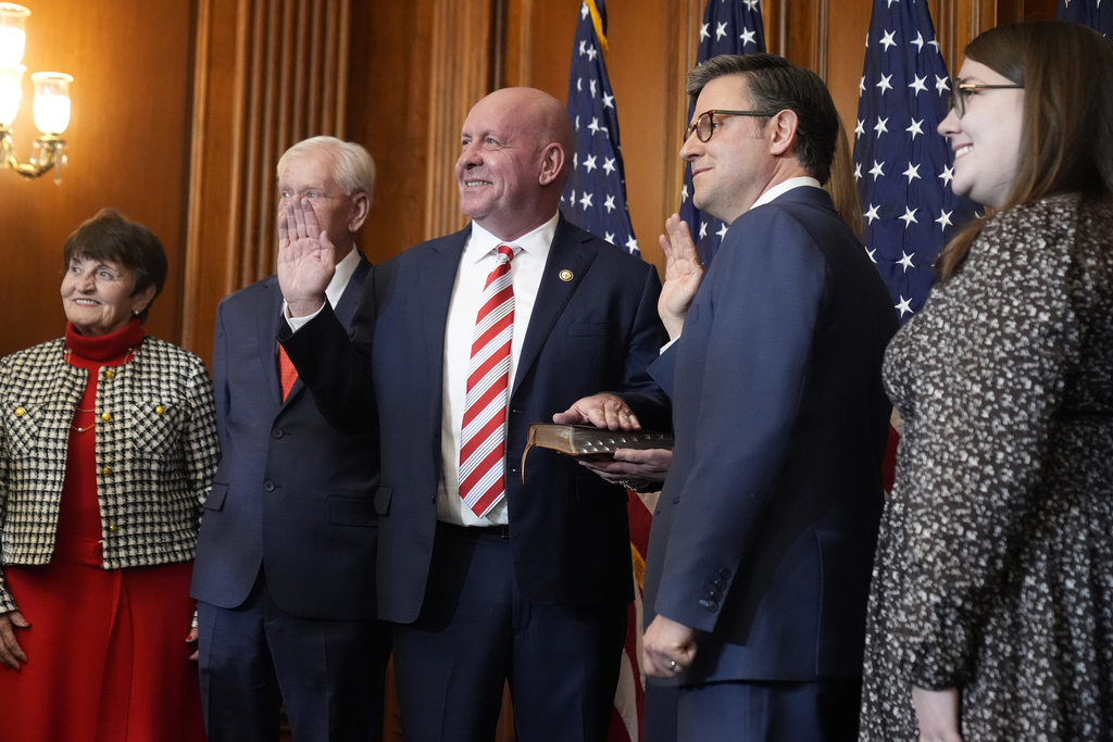 House Speaker Mike Johnson, R-La., second from right, poses during a ceremonial swearing-in with Rep. David Taylor, R-Ohio, in the Rayburn Room at the Capitol in Washington, Friday, Jan. 3, 2025.