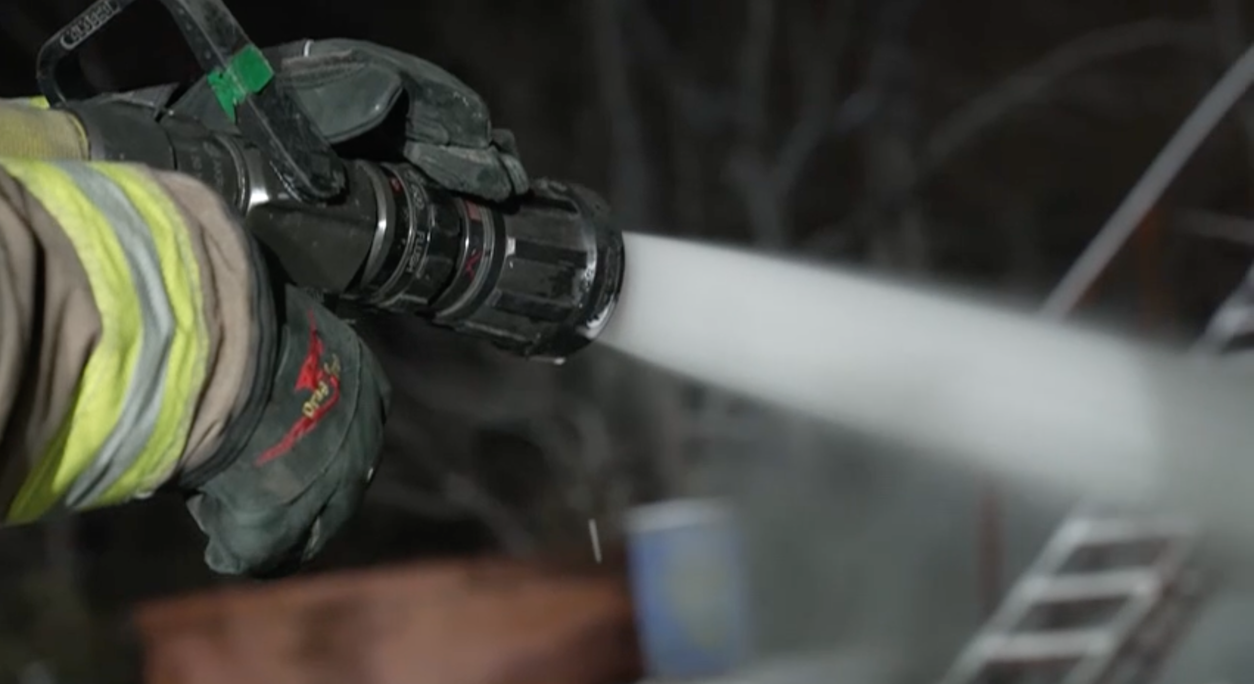 A firefighting hose sprays soy-based firefighting foam