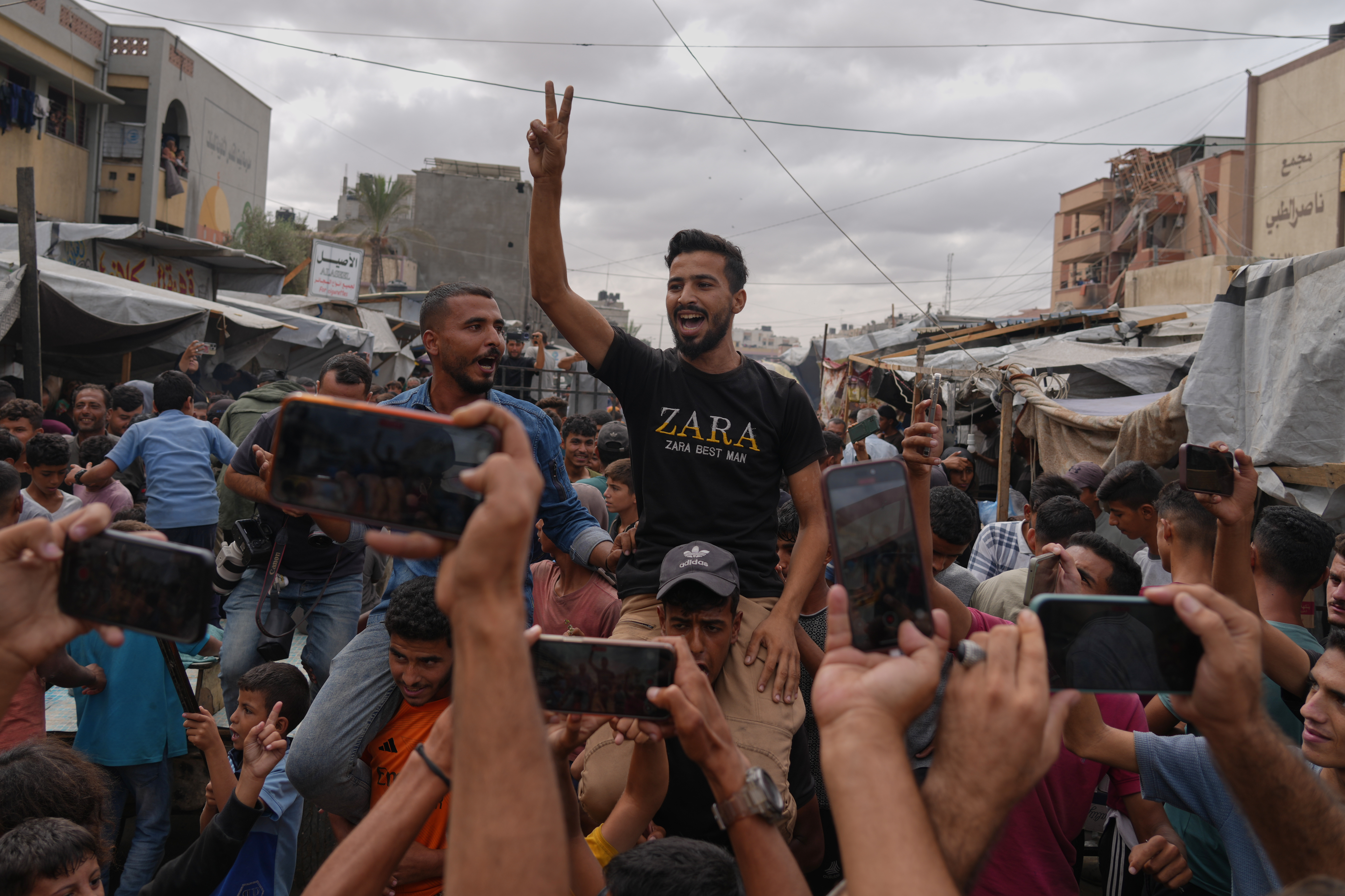 Palestinians celebrate following the announcement that Israel and Hamas have agreed to the first phase of a peace plan to pause the fighting, in Khan Younis, southern Gaza Strip, Thursday, Oct. 9, 2025. 