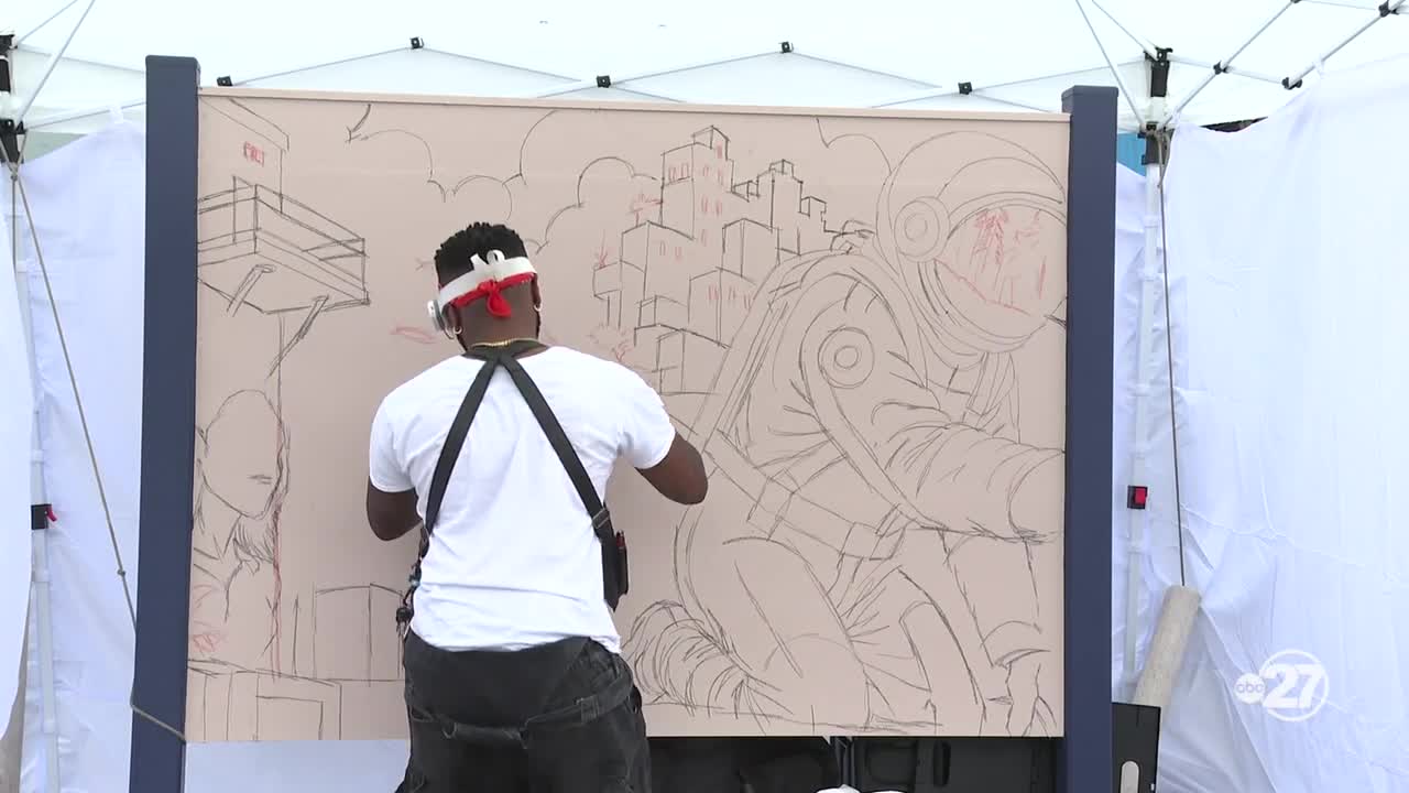 Private investment brings public murals to College Town's Freight Yard fence panels