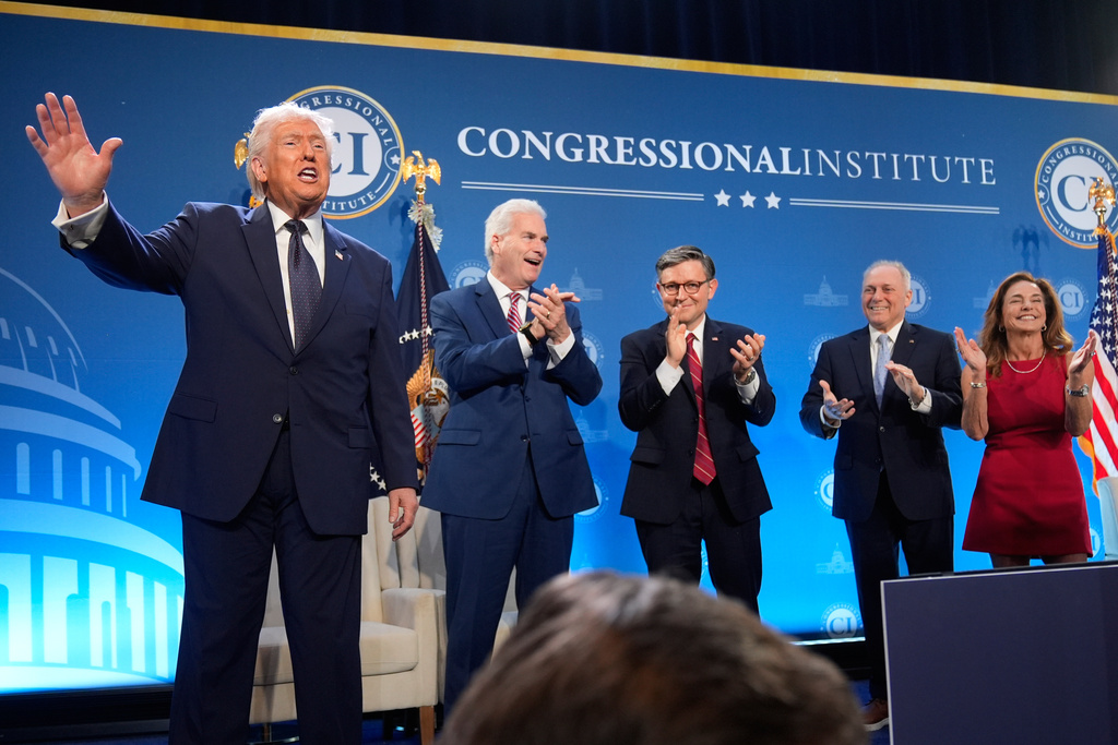 President Donald Trump waves as Rep. Tom Emmer, R-Minn., House Speaker Mike Johnson of La., Rep. Steve Scalise, R-La., and Rep. Lisa McClain, R-Mich., applaud at the Republican Members Issues Conference, Monday, March 9, 2026, at Trump National Doral Miami in Doral, Fla. 