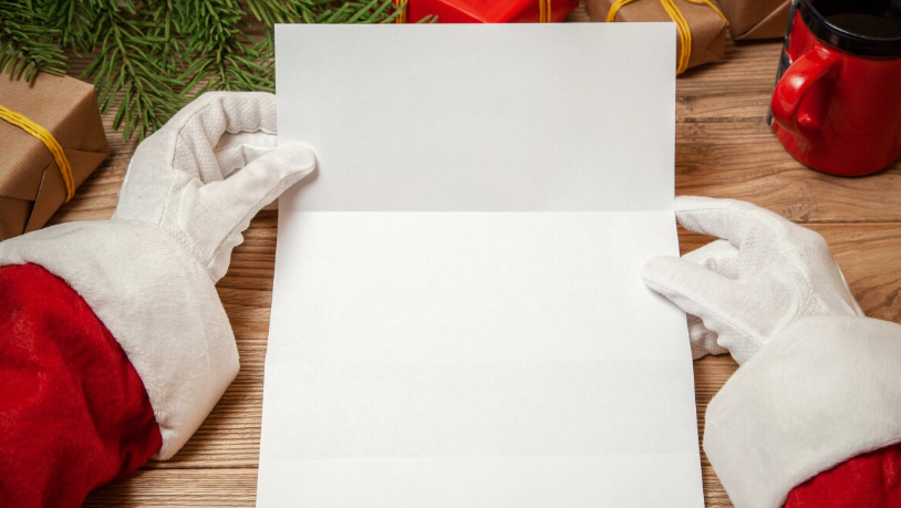 Santa Claus holding a letter.