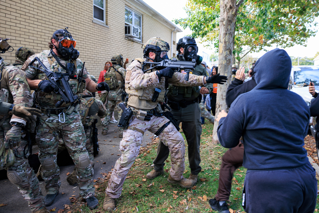 Government officials push back protesters in Chicago, Tuesday, Oct. 14, 2025. 