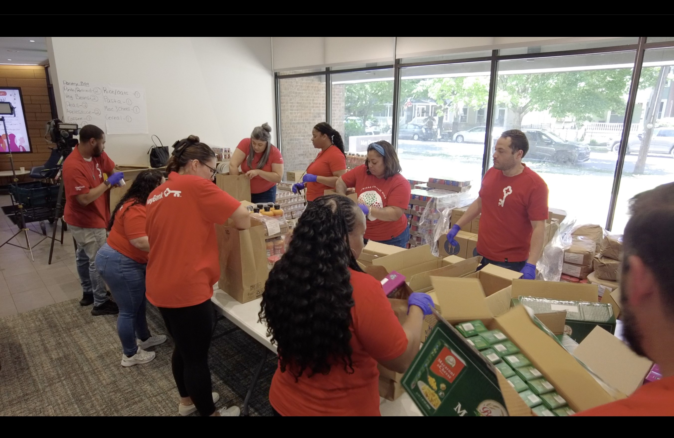 Volunteers from KeyBank help pack food bags at the May Dugan Center