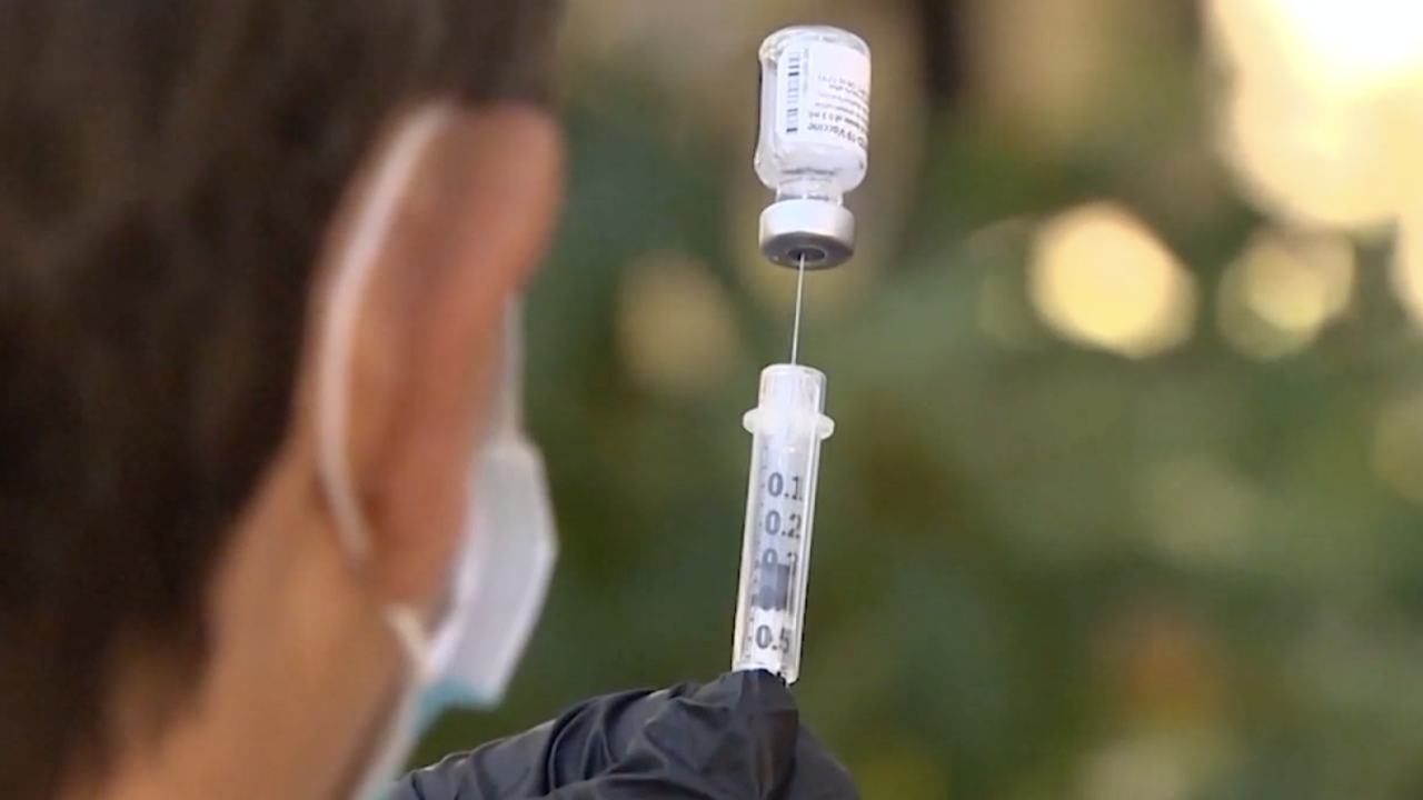 Stock image of a doctor loading a syringe with a flu vaccination.