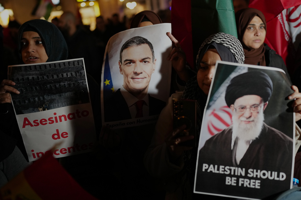 Demonstrators hold photographs of Spanish Prime Minister Pedro Sanchez during a protest against U.S. and Israeli intervention in Iran in Barcelona, Spain, Wednesday, March 4, 2026. 