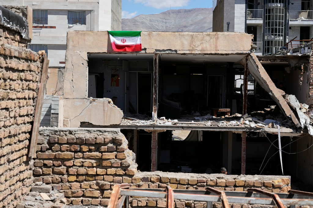 An Iranian flag hangs from the roof of a residential building damaged by recent U.S.-Israeli strikes in Fardis, west of Tehran, Iran, Friday, April 3, 2026. 