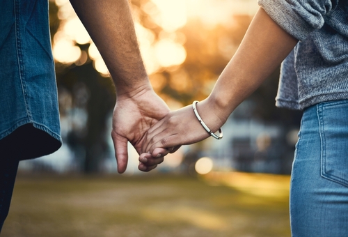 Stock image of a couple holding hands.