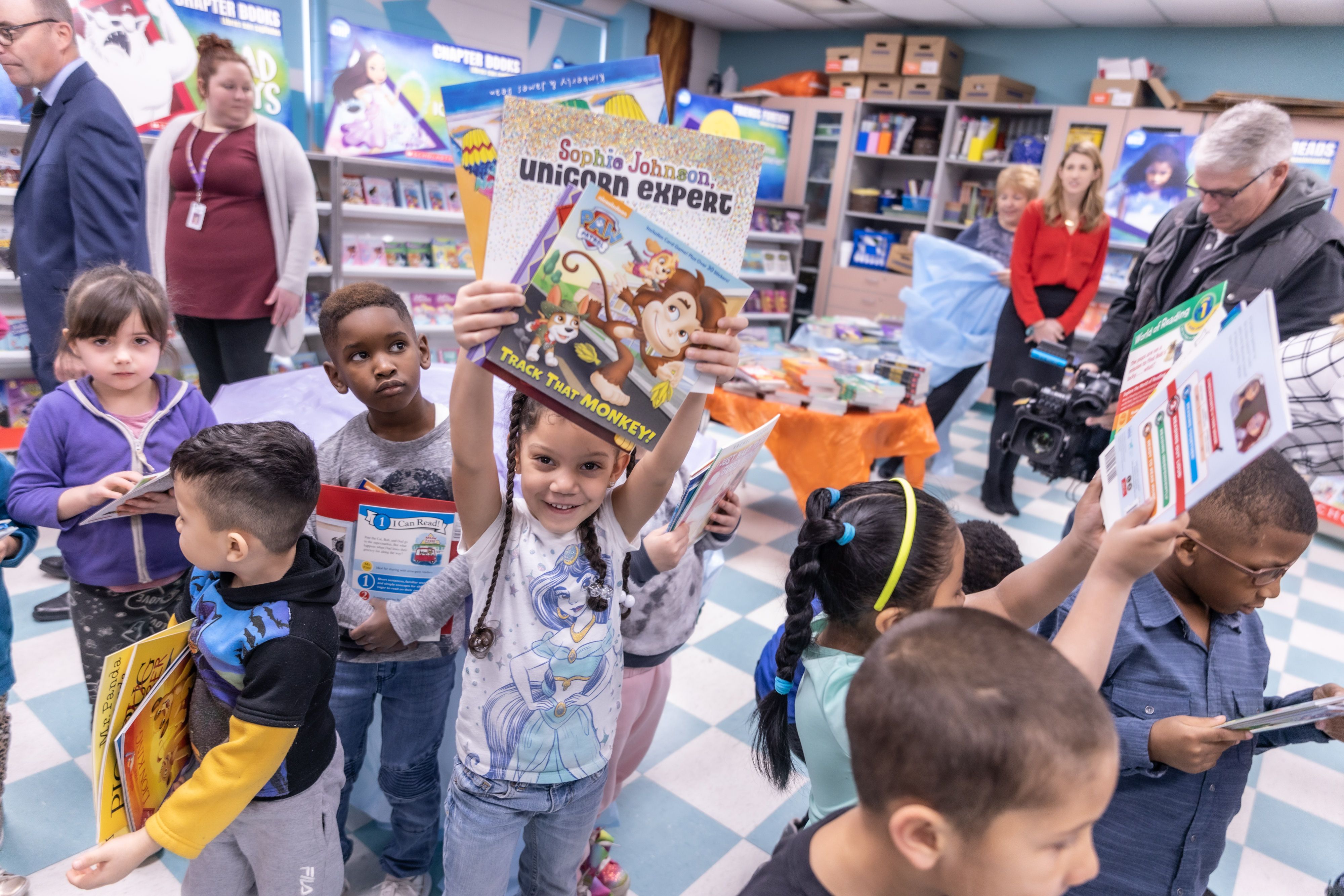 Girl holding books overhead.jpeg