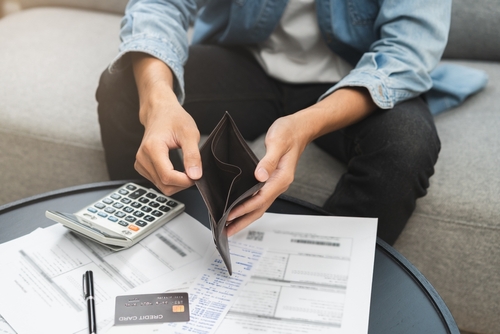 Stock image of a man holding an empty wallet.