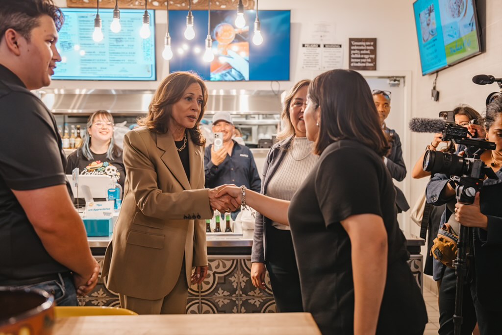 Kamala Harris shakes hands with the niece of the restaurant's owner while picking up tamales from Cocina Adamex