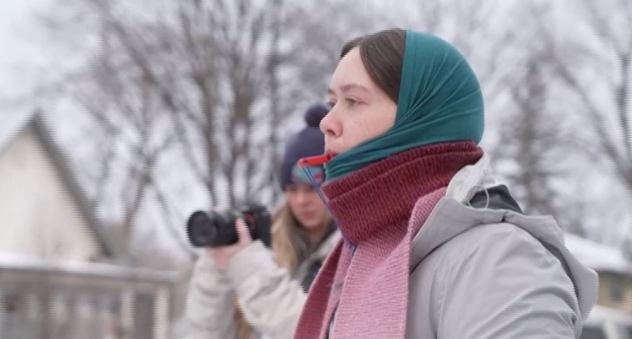 A woman with a whistle protests ICE in a Minneapolis neighborhood.