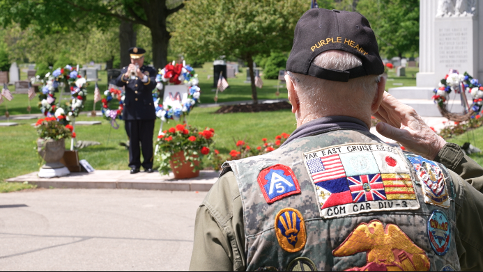 Les Bentley saluting while taps is played at Evergreen Cemetery in Lansing 
