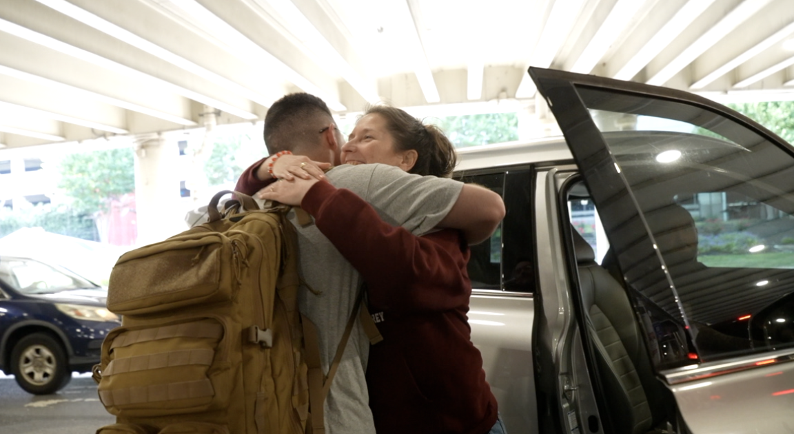 Lance Cpl. Murray and his mother hugging at BWI Airport