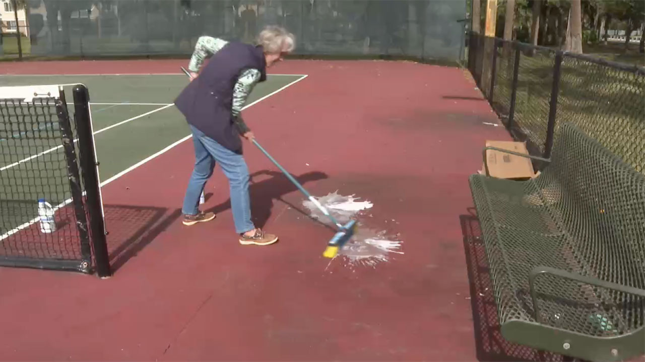 Kathy Robinson cleans urine off the court that she says is left by a homeless person.