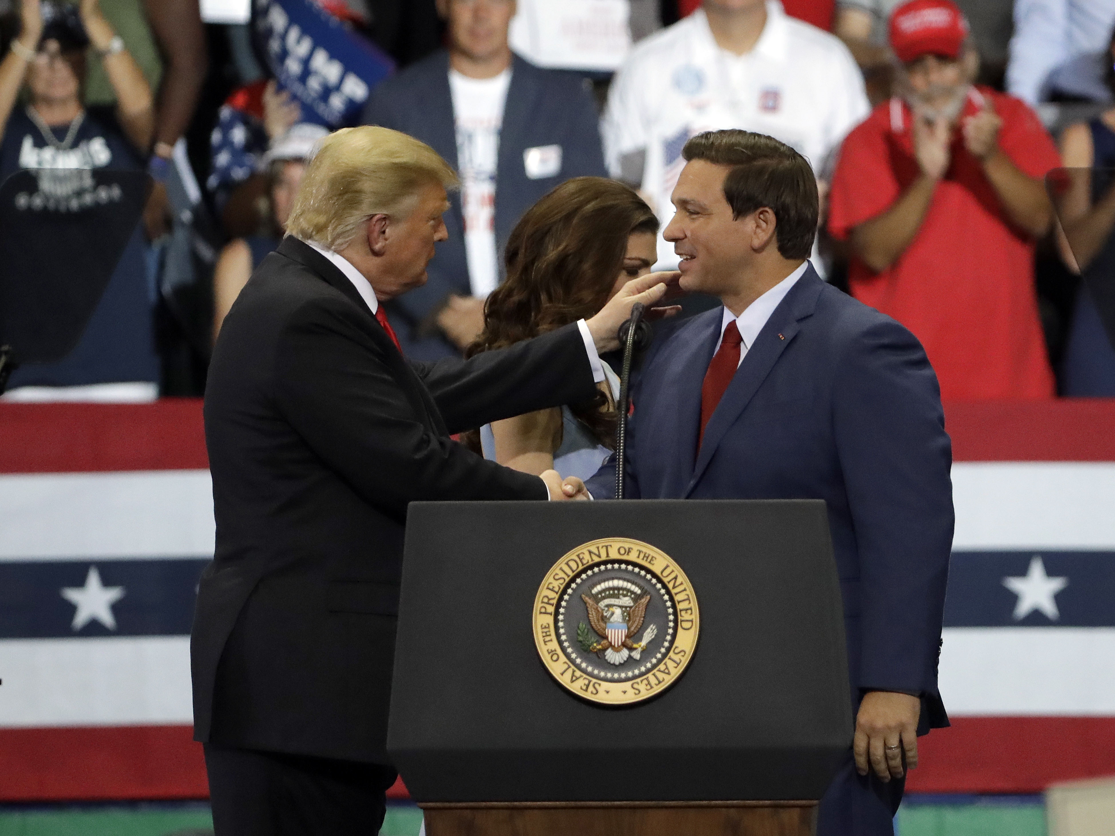 Ron DeSantis shakes hands with President Donald Trump during campaign rally in Estero, Oct. 31, 2018