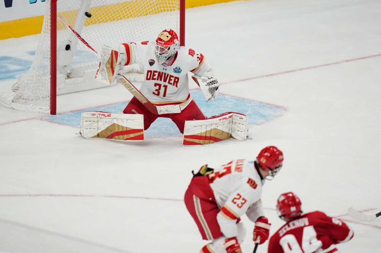 Wisconsin forward Vasily Zelenov (94) scores on Denver goaltender Johnny Hicks (31) in the first period of the championship game at the NCAA Frozen Four men's college hockey tournament Saturday, April 11, 2026, in Las Vegas.