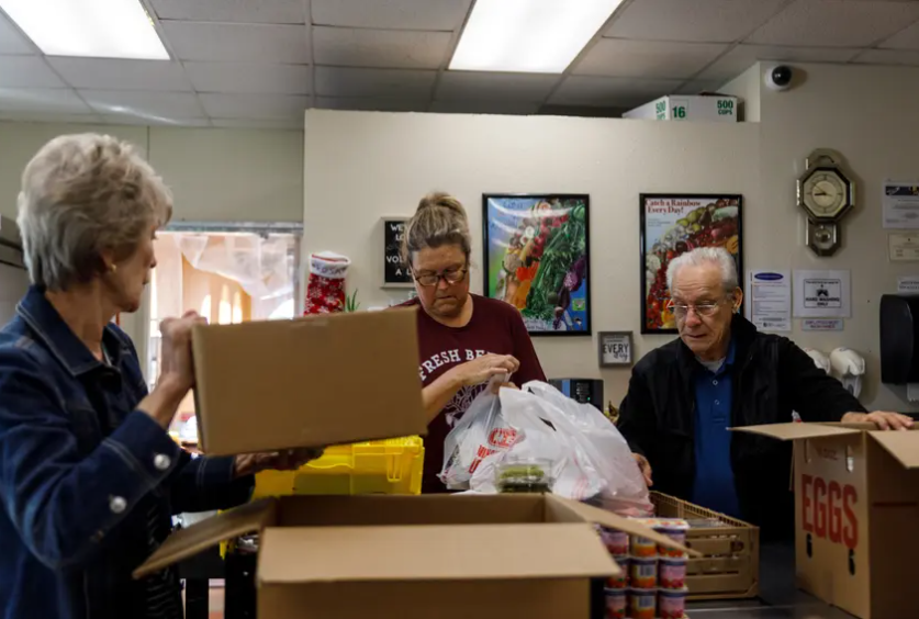 Volunteers from left to right, Evelyn McMillen, Leigh Cox and Victor Surita help to package orders of groceries at El Buen Samaritano food pantry in Austin on Nov. 14. 